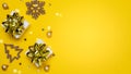 Happy xmas. White gift box with golden color ribbon, New Year balls and sparkling lights in Christmas composition on dark yellow Royalty Free Stock Photo