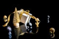 Happy xmas. White gift box with golden ribbon, New Year balls and winter tree in Christmas composition on black background for Royalty Free Stock Photo