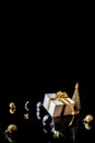 Happy xmas. White gift box with golden ribbon, New Year balls and winter tree in Christmas composition on black background for Royalty Free Stock Photo