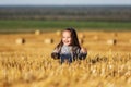 Happy 2 year old girl walking in a summer harvested field