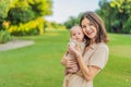 A happy 40-year-old mother cradles her newborn in a sun-drenched park. Love, family and generations in harmony Royalty Free Stock Photo