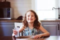 Happy 8 years old child girl having breakfast in country kitchen, drinking milk Royalty Free Stock Photo