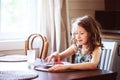 Happy 8 years old child girl having breakfast in country kitchen Royalty Free Stock Photo