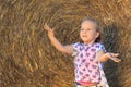 A happy 3 years old girl having fun with hay on a farm Royalty Free Stock Photo