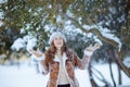 happy 40 years old woman in brown hat and scarf catching snow Royalty Free Stock Photo