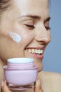 Happy young 40 years old woman with cosmetic cream jar Royalty Free Stock Photo