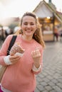 Happy young 40 years old woman at fair in city eating trdelnik