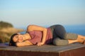 Happy yogi resting in a wooden platform on the beach