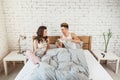 Happy youmg couple in pajamas with glasses of water on bed at home Royalty Free Stock Photo