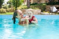 Happy young active mother and curly little baby having fun in a swimming pool Royalty Free Stock Photo