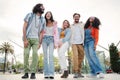 Happy young adult friends having fun at day in the city, laughing, walking and talking together. Group of five carefree Royalty Free Stock Photo