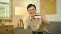 Happy young adult man holding credit card and using laptop for making orders via iInternet or online payment Royalty Free Stock Photo