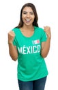 Happy young adult soccer fan from Mexico with green jersey