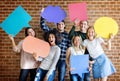 Happy young adults holding empty placard thought bubbles copyspace