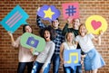 Happy young adults holding thought bubble with social medai concept icons Royalty Free Stock Photo