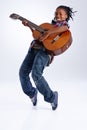 Moved by the music. A happy young African-American boy playing a guitar while balancing on his toes. Royalty Free Stock Photo