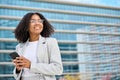 Happy young African American business woman using phone outdoors. Royalty Free Stock Photo