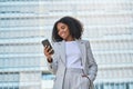 Happy young African American business woman using phone outdoors. Royalty Free Stock Photo