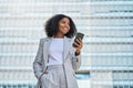 Happy young African American business woman using phone outdoors. Royalty Free Stock Photo