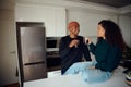 Happy, young African American couple drinking coffee. Mixed race couple looking at each other in the kitchen at home Royalty Free Stock Photo