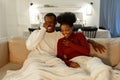 Happy young african american couple laughing at funny joke, watching comedy movie together at home Royalty Free Stock Photo