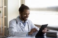 Happy young African American doctor using digital tablet. Royalty Free Stock Photo