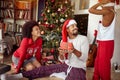 Happy African American Family exchanging gifts in front of decorated Christmas tree Royalty Free Stock Photo