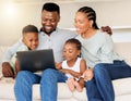 Happy young african american family sitting together and using laptop. Adorable little girl and boy sitting with their Royalty Free Stock Photo