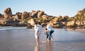 Happy young african american family with two children spending time together and having fun at the beach getting their Royalty Free Stock Photo