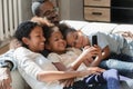 Happy biracial family with small kids relax using cellphone Royalty Free Stock Photo