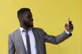 Happy young african american guy in casual t-shirt posing isolated on yellow orange background Royalty Free Stock Photo