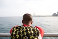 Happy young African-American hipster wearing t-shirt and sunglasses walking at summer day on the beach with backpack and Royalty Free Stock Photo