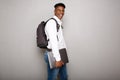 Happy young african american male student holding laptop by gray wall Royalty Free Stock Photo