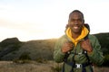 Happy young african american man with with backpack smiling with sunrise in background Royalty Free Stock Photo