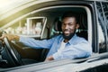 Happy young african american man driving a car on street roads Royalty Free Stock Photo