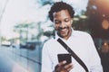 Happy young African American man in headphone walking at sunny city and making video conversation with friends on his Royalty Free Stock Photo