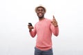 Happy young african american man listening to music with mobile phone and earphones against white background Royalty Free Stock Photo