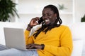 Happy Young African American Man Using Laptop And Talking On Mobile Phone Royalty Free Stock Photo
