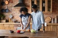Happy young african american man watching wife preparing food. Royalty Free Stock Photo