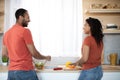 Happy young african american man and woman preparing salad with organic vegetables together Royalty Free Stock Photo