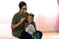 Happy young African American mother having fun with daughter child girl playing and hugging in bedroom at home Royalty Free Stock Photo