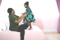 Happy young African American mother having fun with daughter child girl playing and hugging in bedroom at home Royalty Free Stock Photo