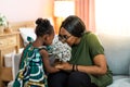 Happy young African American mother having fun with daughter child girl playing and hugging in bedroom at home Royalty Free Stock Photo