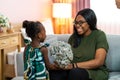 Happy young African American mother having fun with daughter child girl playing and hugging in bedroom at home Royalty Free Stock Photo