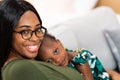 Happy young African American mother having fun with daughter child girl playing and hugging in bedroom at home Royalty Free Stock Photo