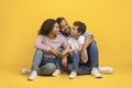 Happy young african american parents sitting on floor with their little son, Royalty Free Stock Photo