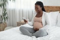 Happy Young African American Pregnant Woman Relaxing With Smartphone At Home Royalty Free Stock Photo