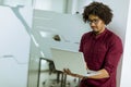 Happy young African American IT specialist wearing glasses working on his laptop in the office Royalty Free Stock Photo