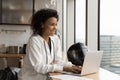 Smiling biracial woman biker work on laptop at home