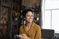 Happy young African American woman with cellphone looking in distance. Royalty Free Stock Photo